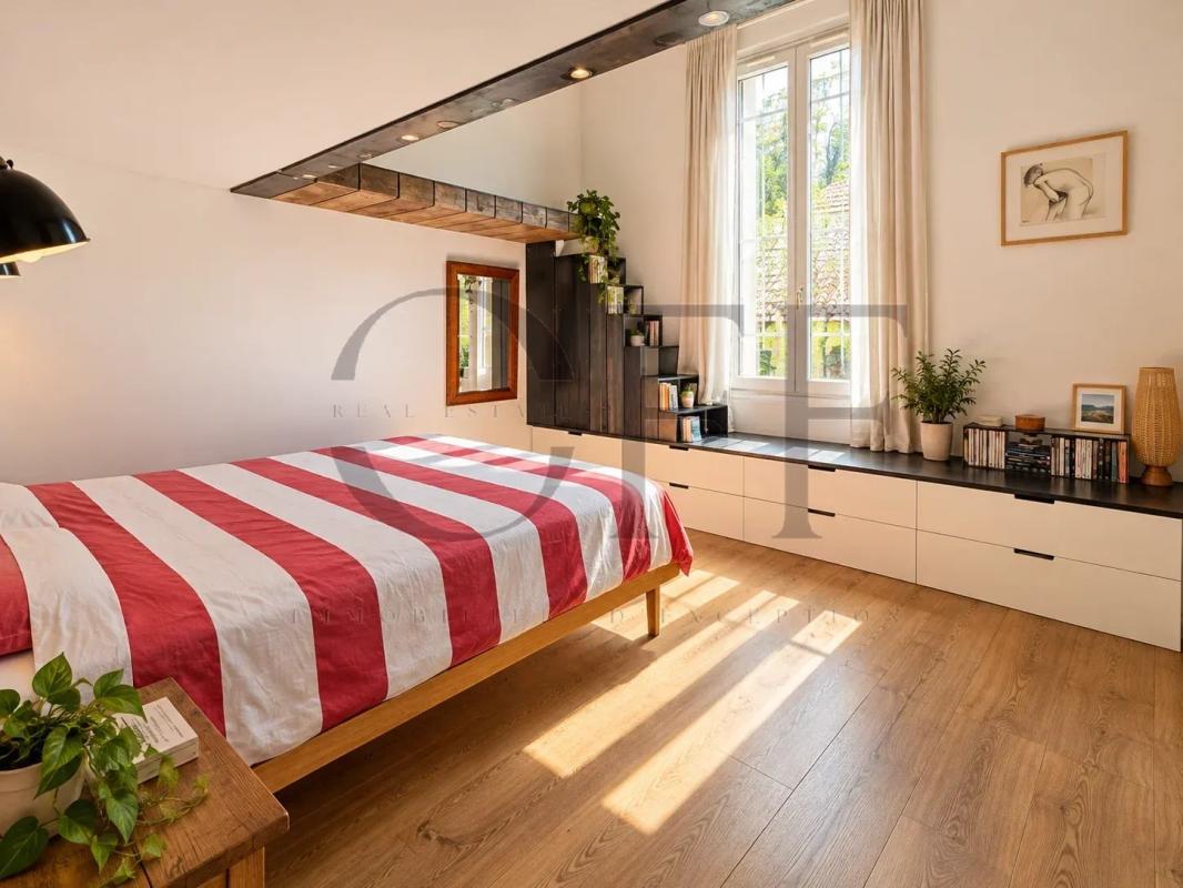Chambre rénovée dans une maison de ville à Marseille Chambre d'une maison de ville rénovée avec lit à rayures et espace de rangement.