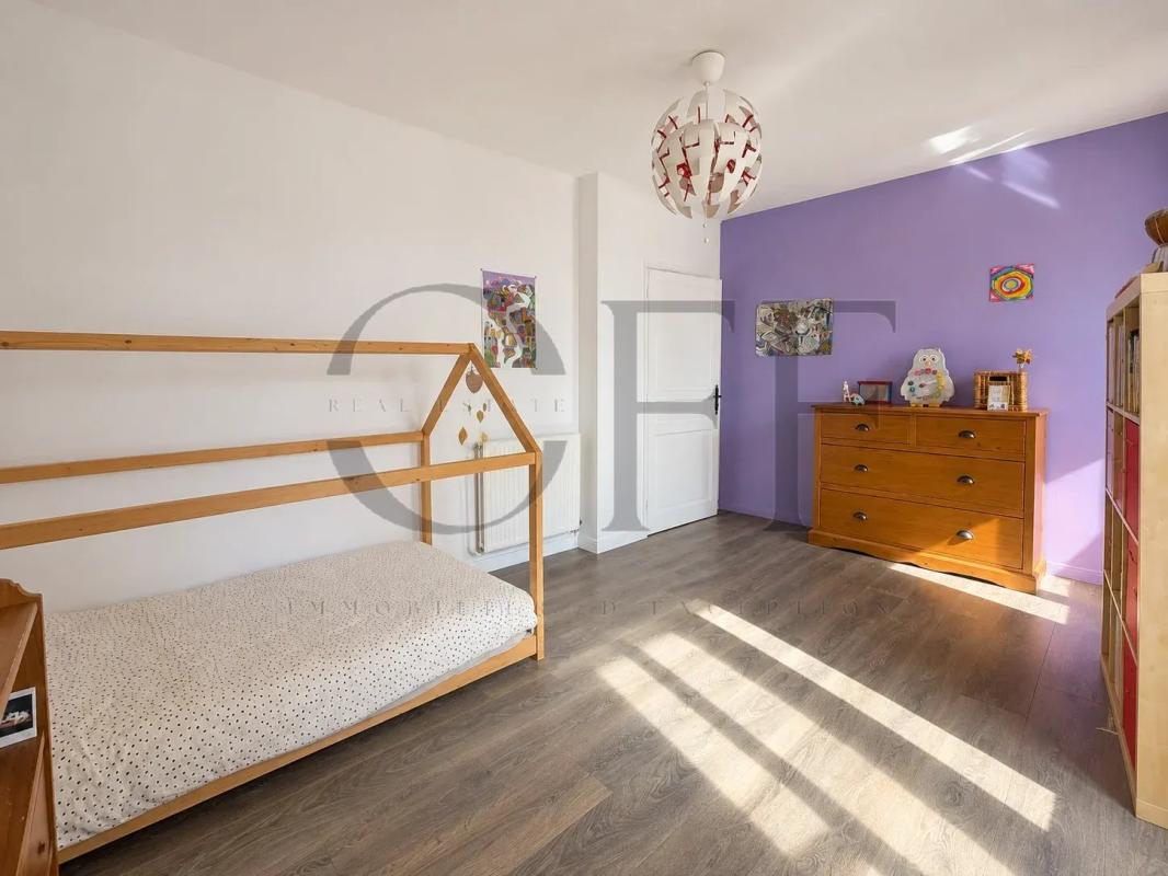 Chambre rénovée à Marseille Chambre d'une maison de ville rénovée à Marseille, avec un lit en bois et un mur violet.