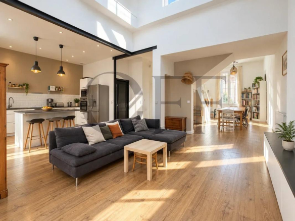 Intérieur d'une maison de ville rénovée avec salon lumineux et cuisine ouverte.