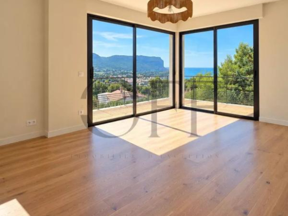 Intérieur d'une villa contemporaine à Cassis avec vue sur la mer, grandes baies vitrées et parquet en bois.