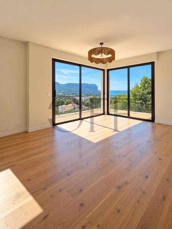 Intérieur d'une villa contemporaine à Cassis avec vue sur la mer, grandes baies vitrées et parquet en bois.