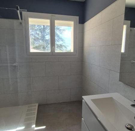 Salle de bain moderne avec douche et meuble lavabo dans une maison à Saint-Aunès.