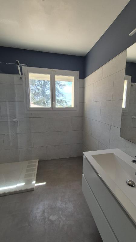 Salle de bain moderne avec douche et meuble lavabo dans une maison à Saint-Aunès.