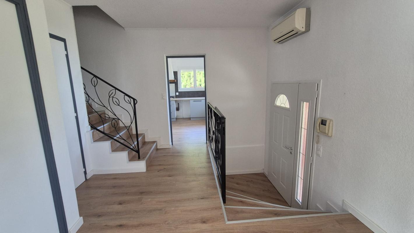 Intérieur d'une maison à Saint-Aunès avec un hall d'entrée et un escalier.