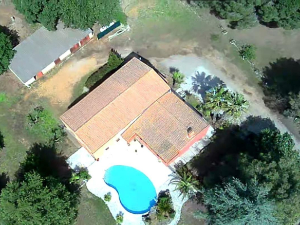 Vue aérienne d'une maison avec piscine sur un grand terrain arboré à Saint-Aunès.