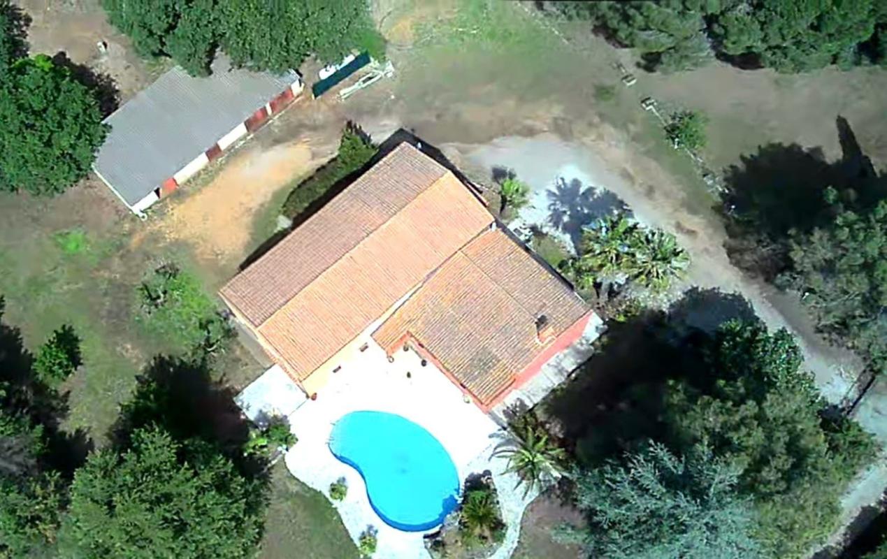 Vue aérienne d'une maison avec piscine sur un grand terrain arboré à Saint-Aunès.
