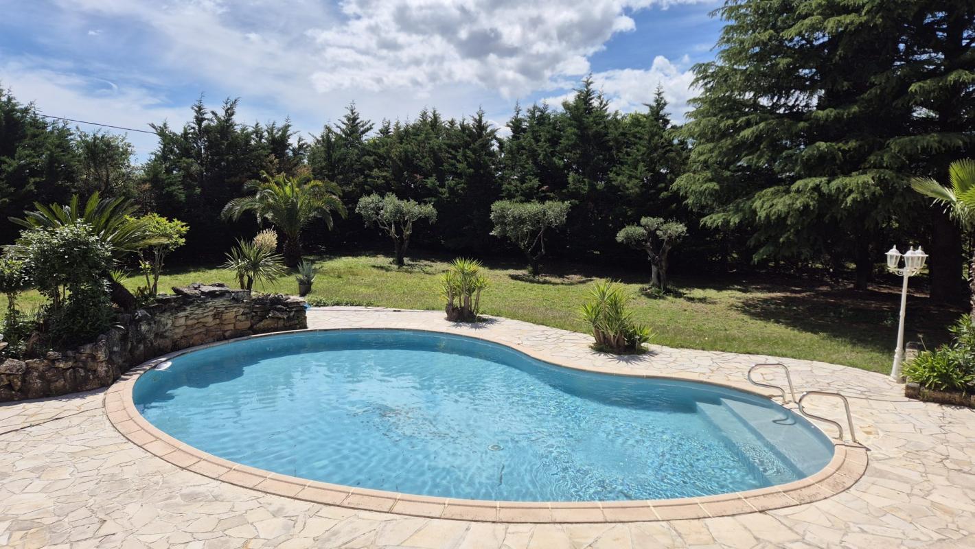 Piscine entourée d'un jardin verdoyant dans une propriété à Saint-Aunès.