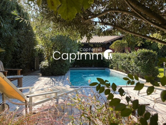 View of the swimming pool and garden of a villa in Lège-Cap-Ferret.