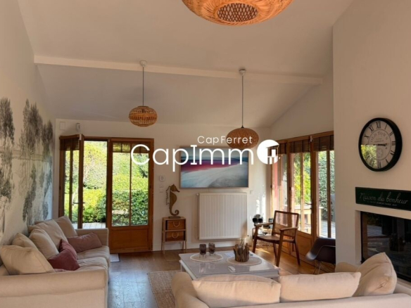 Interior of a villa in Lège-Cap-Ferret with a bright living room and windows overlooking the garden.