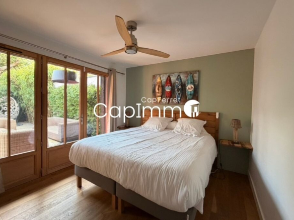 Room in a villa in Lège-Cap-Ferret with double bed and access to an outdoor area.