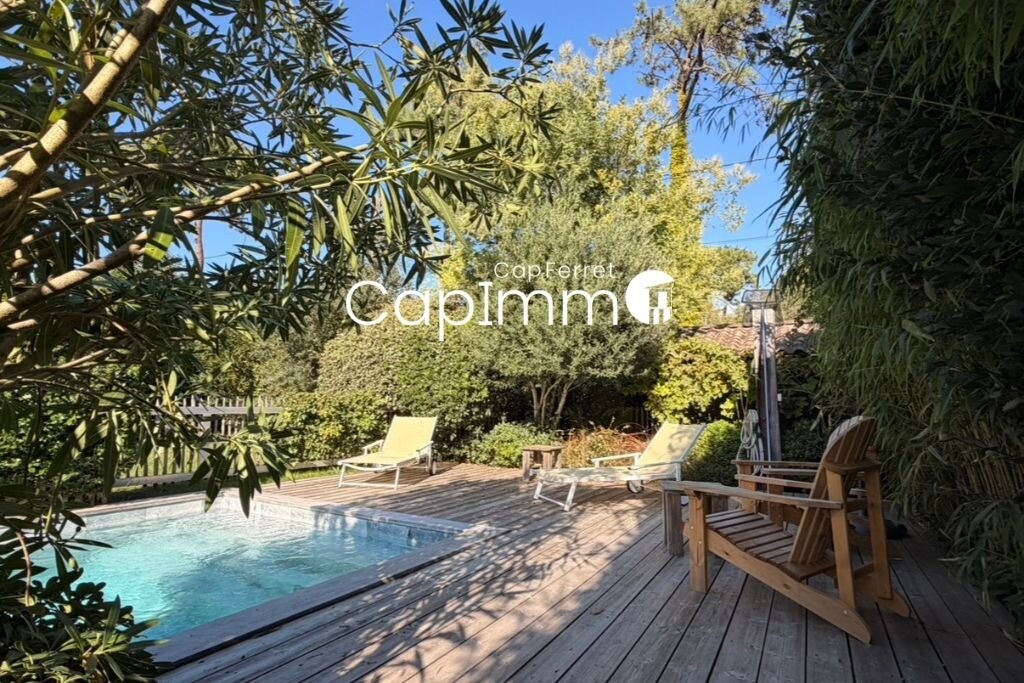 Villa with swimming pool in Lège-Cap-Ferret Wooden terrace with sun loungers and swimming pool, surrounded by greenery in a villa in Lège-Cap-Ferret.