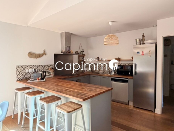 Modern kitchen in a villa in Lège-Cap-Ferret with bar and contemporary equipment.