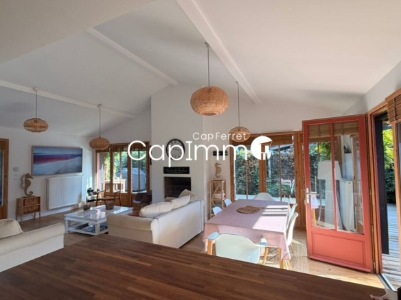 Interior of a bright villa in Lège-Cap-Ferret with living room, dining room and open kitchen.