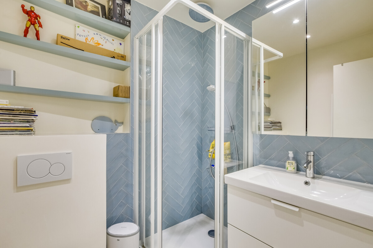 Salle de bain rénovée à Paris 15ème Salle de bain moderne avec douche et lavabo dans un appartement rénové à Paris 15ème.