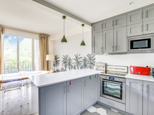 Cuisine moderne avec vue sur un jardin, équipée et lumineuse, dans un appartement à Paris 15ème.