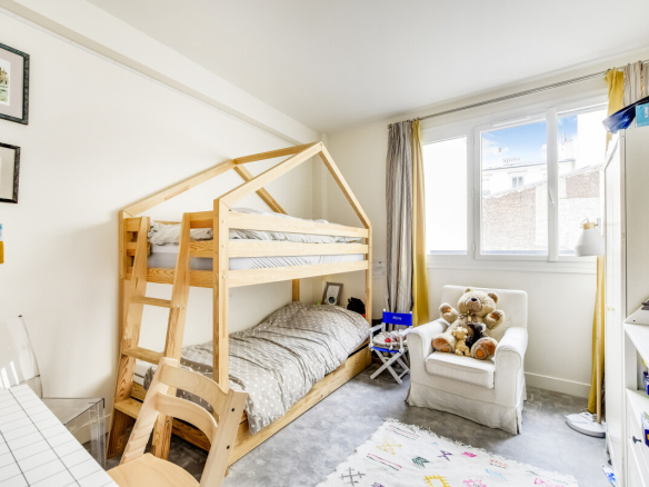 Chambre d'enfant avec lit superposé en bois et décoration lumineuse, Paris 15ème.