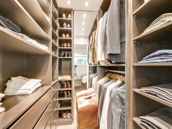 Dressing spacieux avec étagères et vêtements bien organisés.
