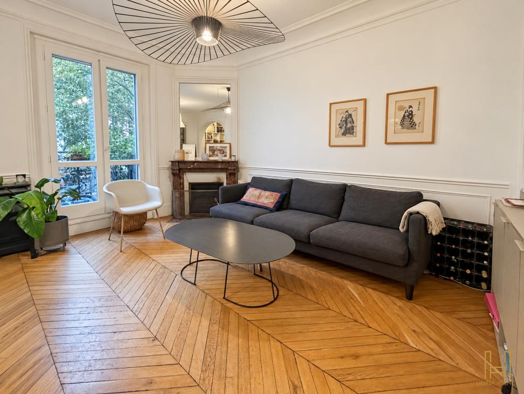 Apartment living room in the 9th arrondissement of Paris Living room of a Haussmannian apartment in the 9th arrondissement of Paris, with herringbone parquet flooring and modern furniture.