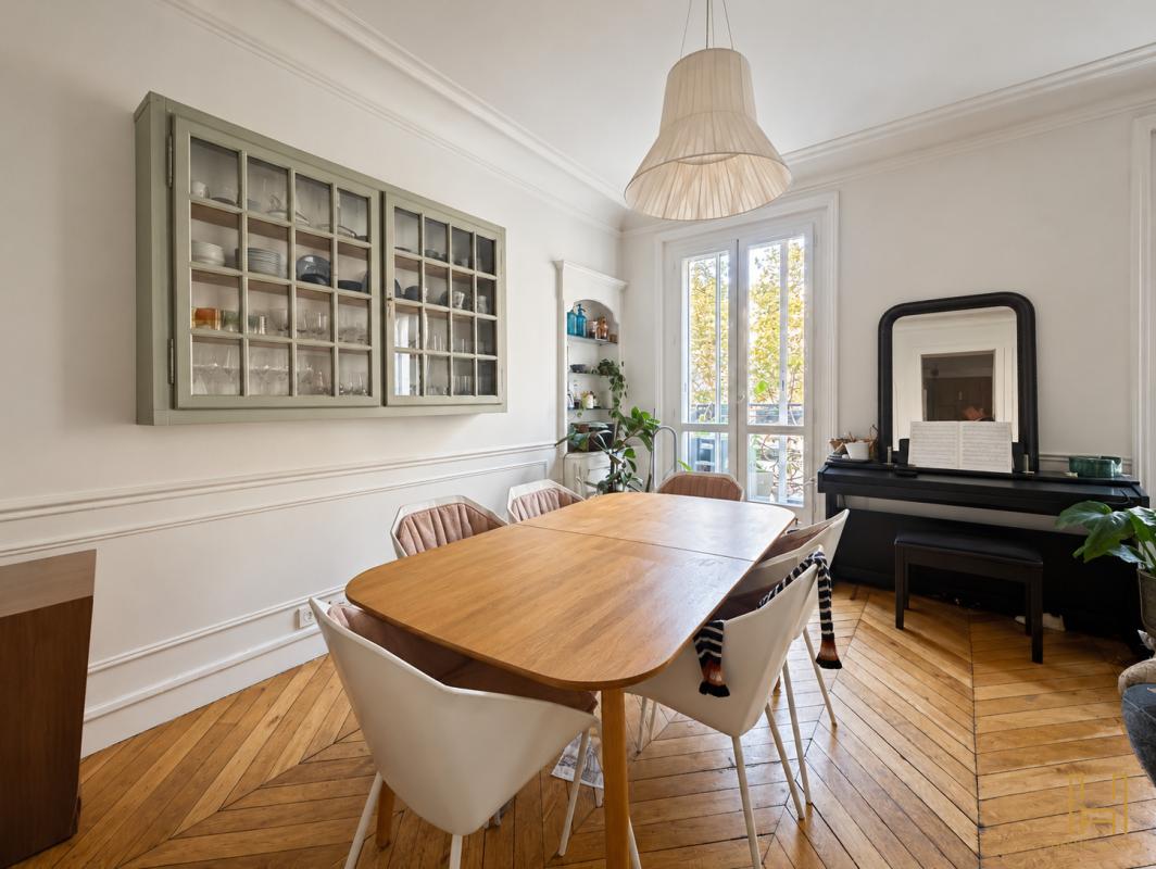 Dining room of a Haussmannian apartment Dining room of a Haussmannian apartment in Paris with wooden table and modern chairs.