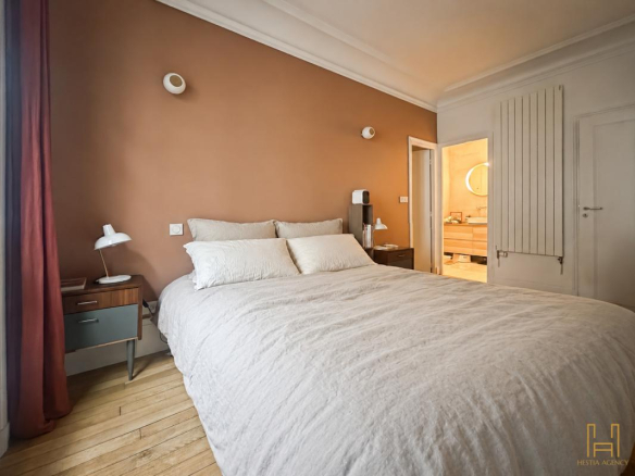 Room in a Haussmannian apartment in Paris 9th arrondissement with double bed and elegant decor.