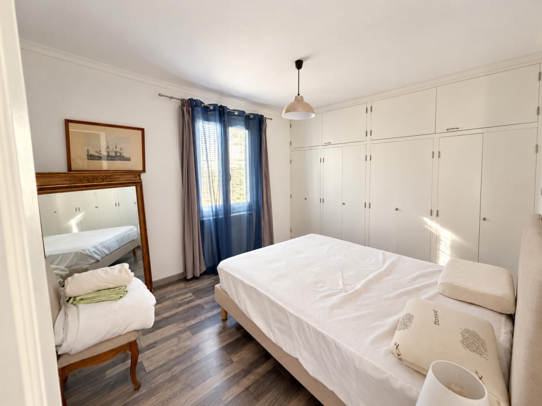 Chambre d’une propriété à La Gaude Chambre d'une propriété avec un lit simple, un miroir et des placards intégrés.