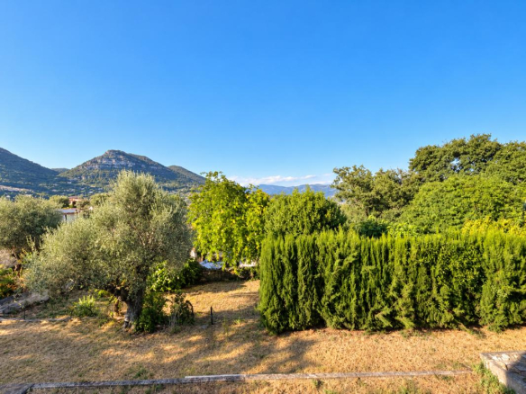 Vue dégagée sur les Baous depuis un terrain arboré avec piscine.