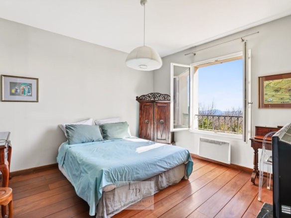 Chambre d'une villa avec vue sur la nature et la mer Méditerranée, calme et élégante.