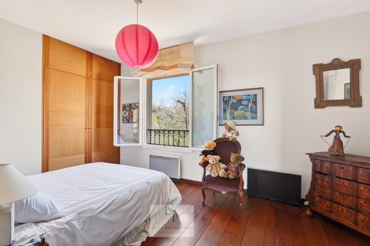 Chambre de villa à Mons Chambre d'une villa avec fenêtre ouverte et meubles en bois, décorée de peluches.