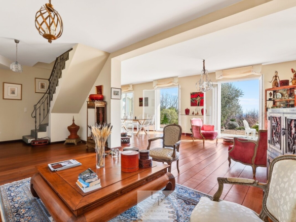 Intérieur d'une villa élégante avec vue sur un paysage provençal, mobilier raffiné et lumière naturelle.