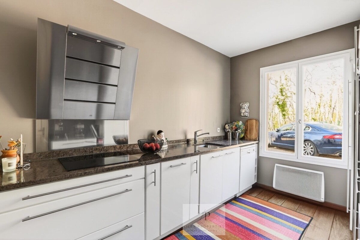 Cuisine moderne dans une villa Cuisine moderne avec plans de travail en granit et fenêtre donnant sur l'extérieur.