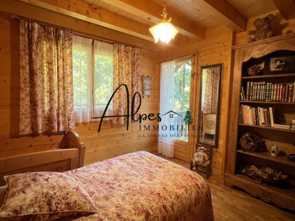 Chambre d'un chalet en bois avec lit et bibliothèque, La Clusaz