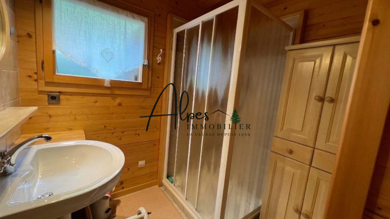 Salle de bain du chalet Salle de bain dans un chalet en bois avec douche et lavabo