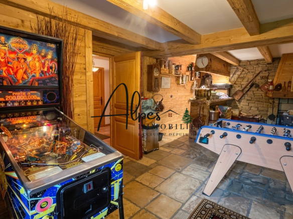 Intérieur d'un chalet avec un flipper et une table de baby-foot.