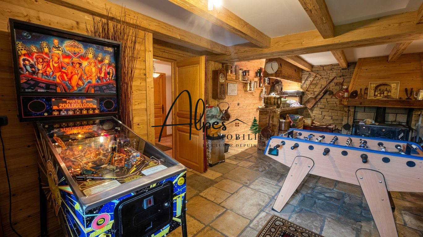 Chalet d’exception à La Clusaz Intérieur d'un chalet avec un flipper et une table de baby-foot.