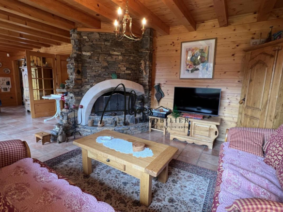 Intérieur d'un chalet en bois avec cheminée et mobilier traditionnel à La Clusaz.