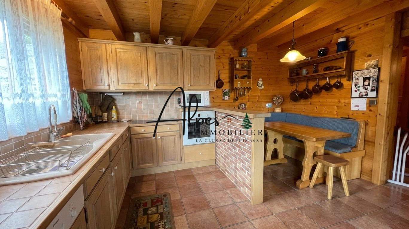 Cuisine d’un chalet à La Clusaz Cuisine en bois d'un chalet avec table et banc, vue sur le plan de travail en carrelage.