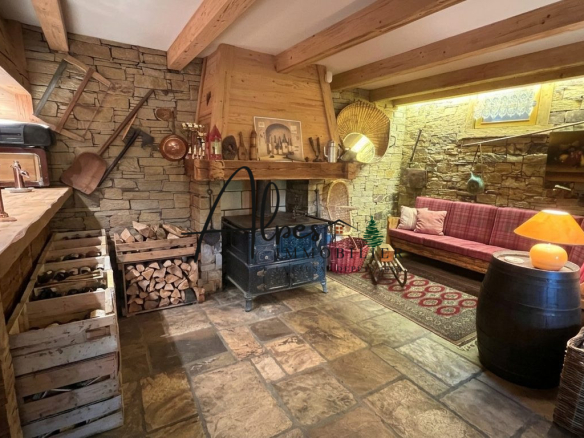 Intérieur d'un chalet en bois avec cheminée, canapé et décor traditionnel.