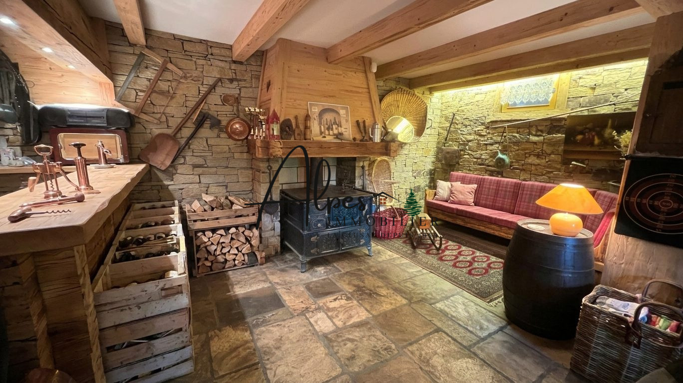 Intérieur d’un chalet d’exception à La Clusaz Intérieur d'un chalet en bois avec cheminée, canapé et décor traditionnel.