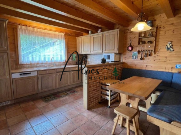 Intérieur d'un chalet en bois avec cuisine équipée et coin repas à La Clusaz.