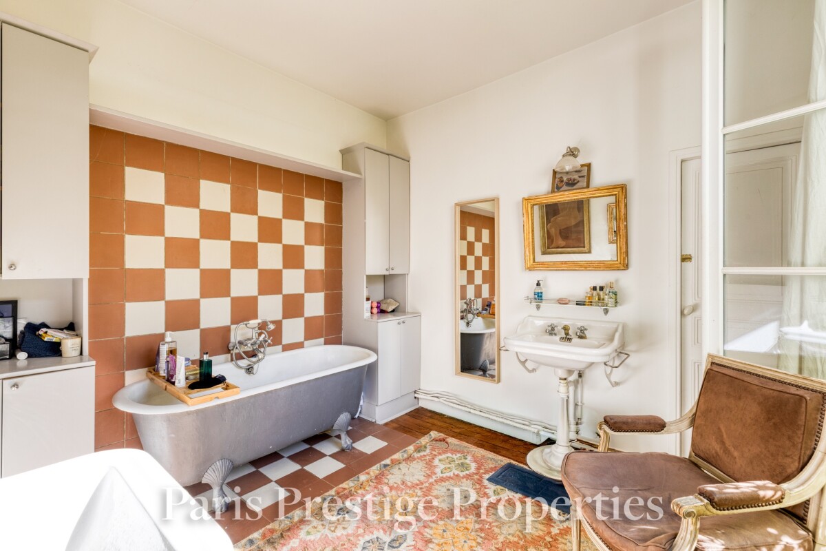 Salle de bain d’un atelier d’artiste à Paris Salle de bain d'un ancien atelier d'artiste à Paris, avec baignoire, lavabo et miroir.