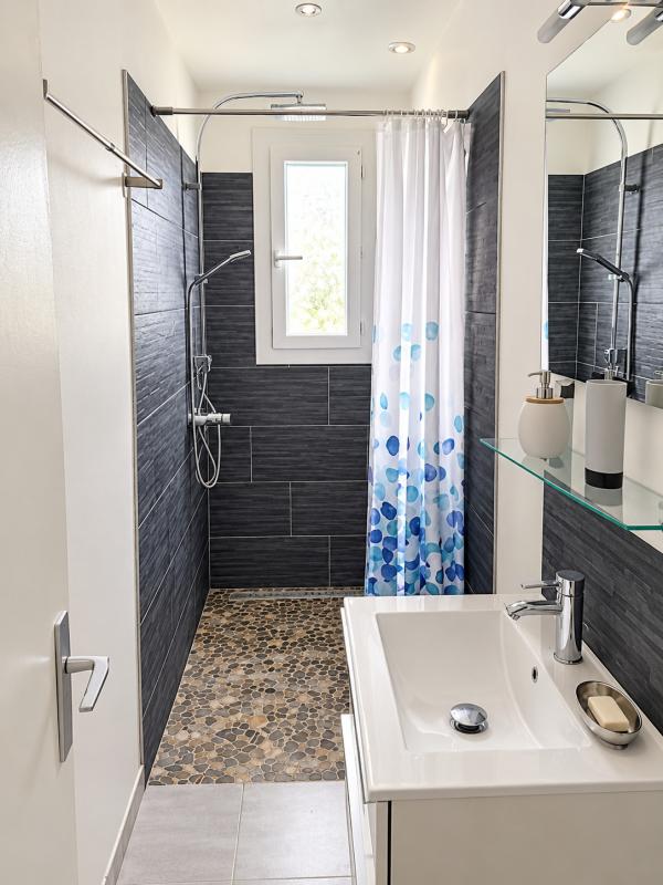 Salle de bain moderne Salle de bain moderne avec douche à l'italienne et lavabo, décorée de carrelage gris et mosaïque.