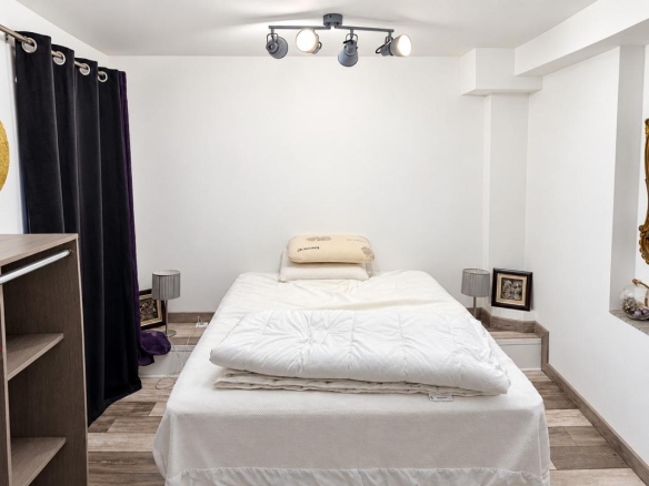 Chambre d'une propriété avec lit et décoration simple.
