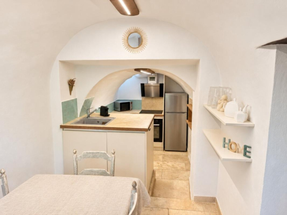 Intérieur d'une cuisine voûtée d'une bergerie du XVIIIᵉ siècle à Lorgues, avec table et équipements modernes.