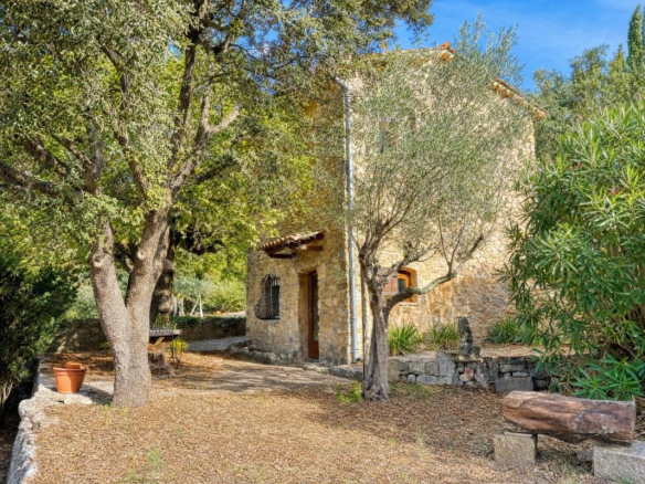 Maison en pierre du XVIIIᵉ siècle entourée d'arbres et de verdure à Lorgues.