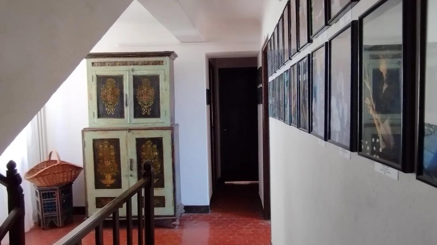 Intérieur d’une ancienne auberge à Coursegoules Intérieur d'une ancienne auberge avec des cadres accrochés au mur et un meuble ancien.