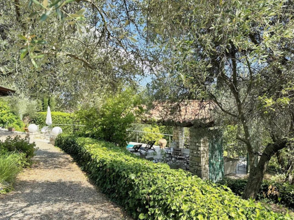Chemin menant à une villa avec piscine entourée d'arbres et de verdure à Le Tignet.