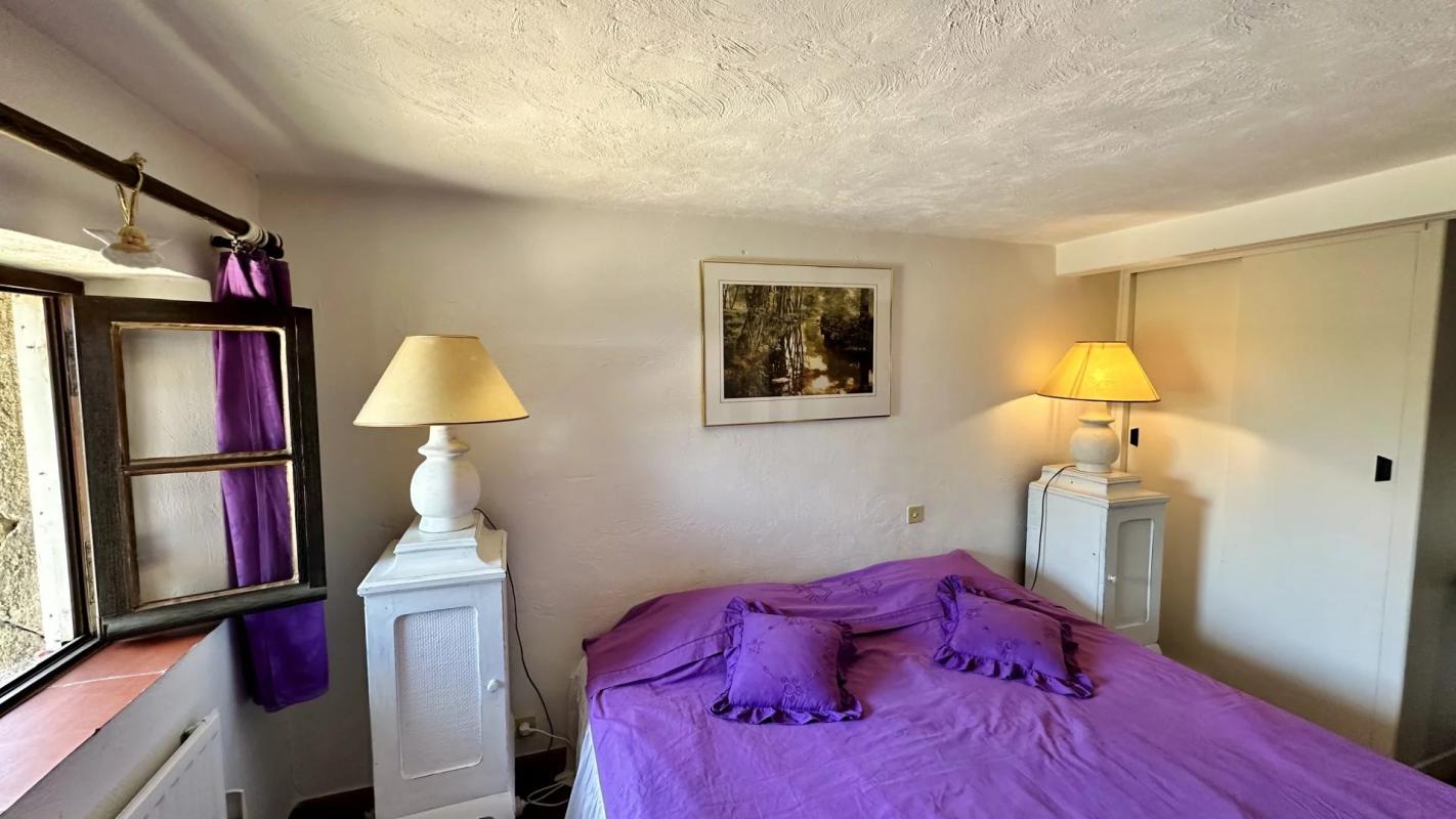 Chambre de villa au Tignet Chambre d'une villa avec lit double et lampes de chevet, fenêtres et décoration simple.