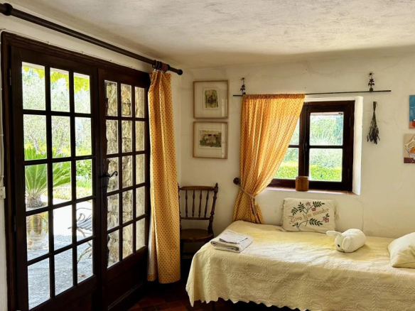 Intérieur d'une villa avec lit, fenêtres à carreaux, et décoration chaleureuse.