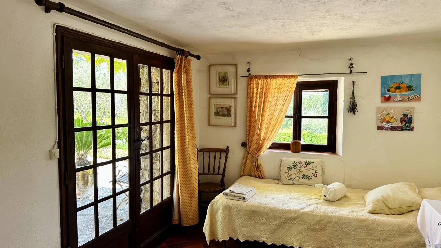Intérieur d’une villa de charme Intérieur d'une villa avec lit, fenêtres à carreaux, et décoration chaleureuse.
