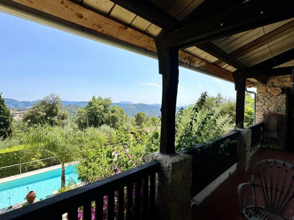 Vue de la piscine et du jardin depuis la terrasse d'une villa au Tignet, avec panorama sur les collines provençales.